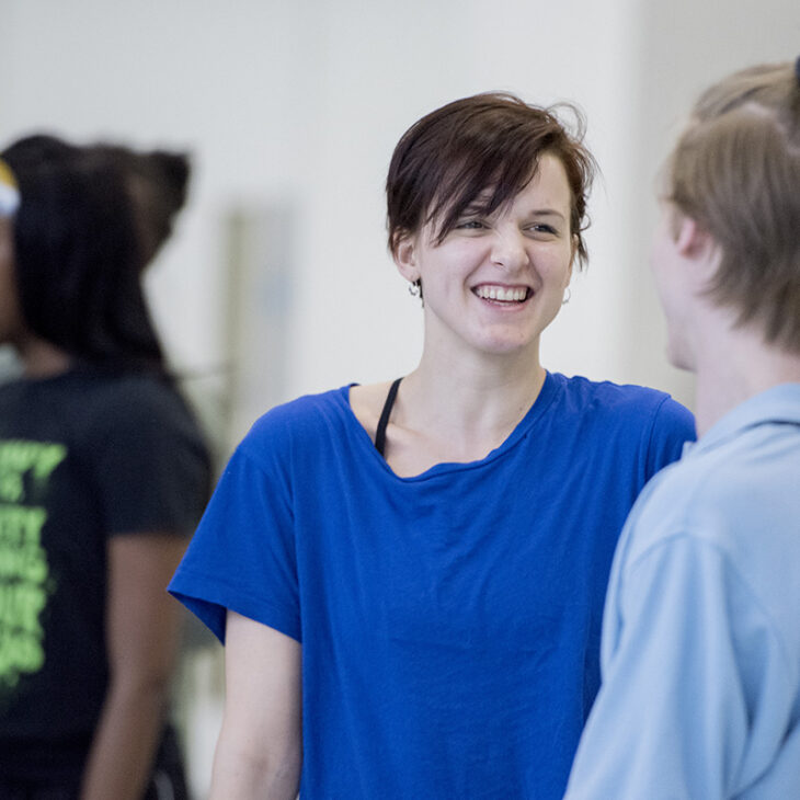 A woman in a blue shirt smiling.